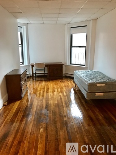 A room with wooden floors and a bed in it.