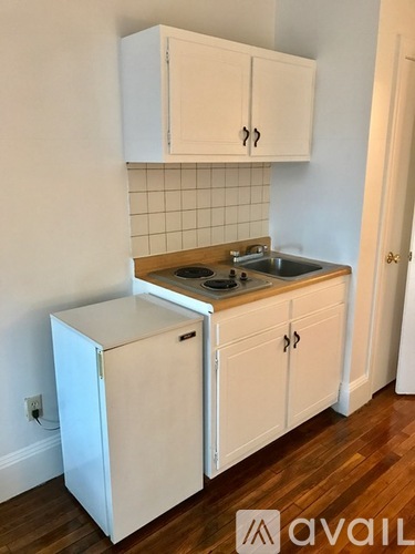 A kitchen with white cabinets and a white fridge.