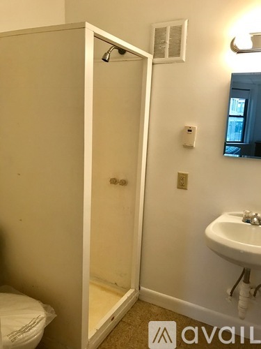 A white bathroom with a toilet, sink and shower.