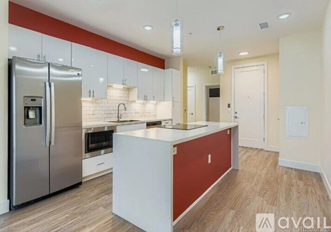 A modern kitchen with a stainless steel refrigerator and a central island.