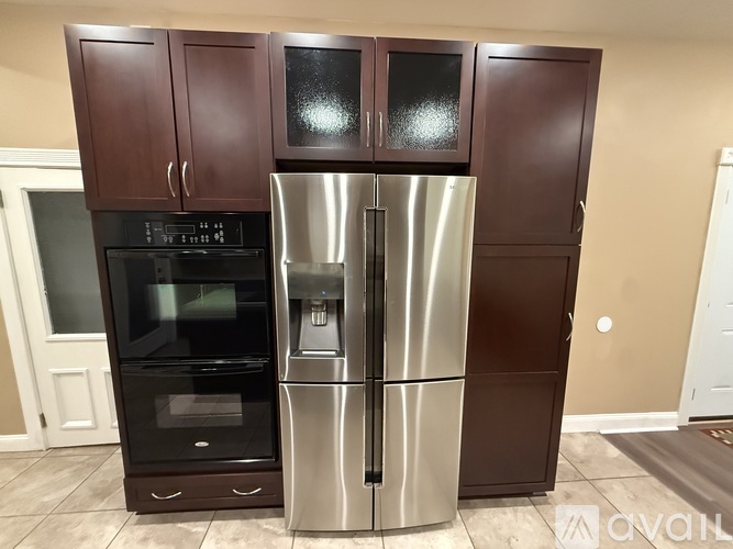 A kitchen with brown cabinets and a stainless steel refrigerator.
