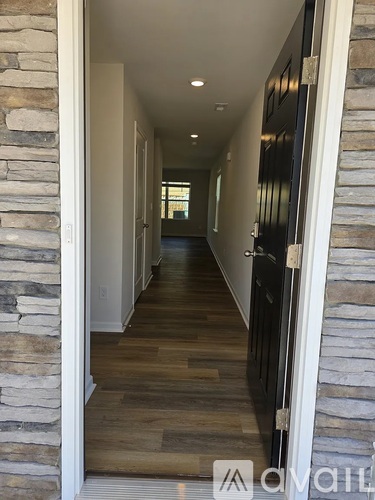 A long hallway with stone walls and wood floors.