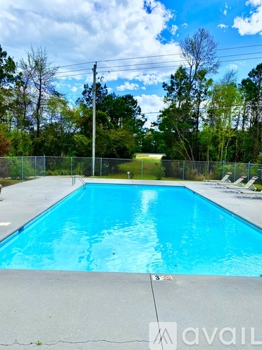 A pool with a fence and trees in the background.