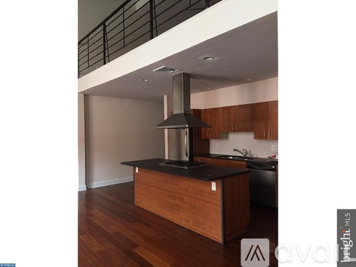 A kitchen with a black countertop and a stainless steel range hood.