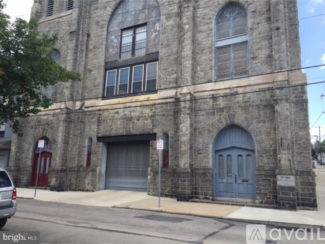 A stone building with a red door and a blue door.