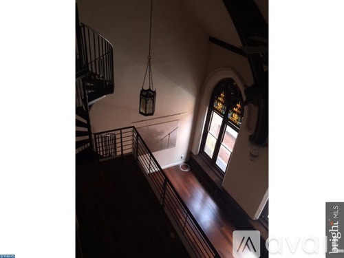 A staircase with a metal railing and a hanging lantern.
