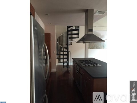 A kitchen with a stainless steel refrigerator and a stove top oven.