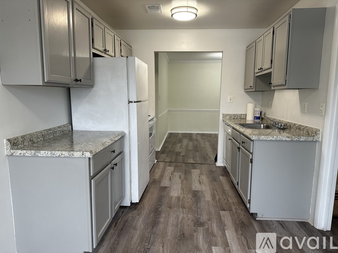 A kitchen with white cabinets and a marble countertop.