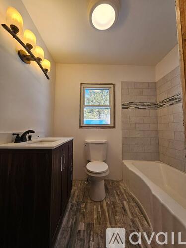 A bathroom with a toilet, sink, and tub.