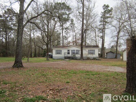 A house is surrounded by trees in a wooded area.