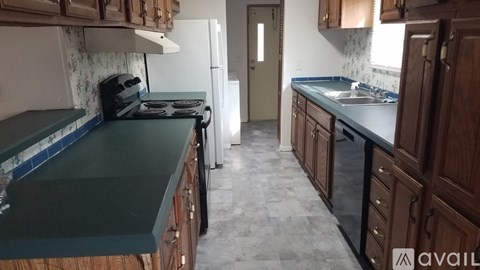 A kitchen with wooden cabinets and a green countertop.