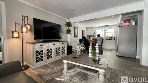 A modern living room with a grey sofa and a television on a cabinet.