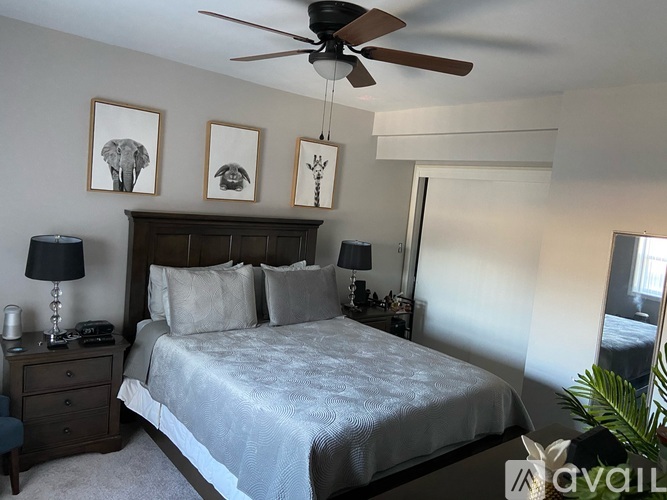 A bedroom with a bed, nightstands, and a ceiling fan.