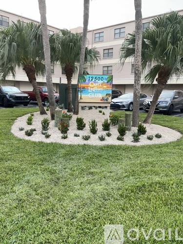 A sign for a 2500 club is in front of a building with palm trees.