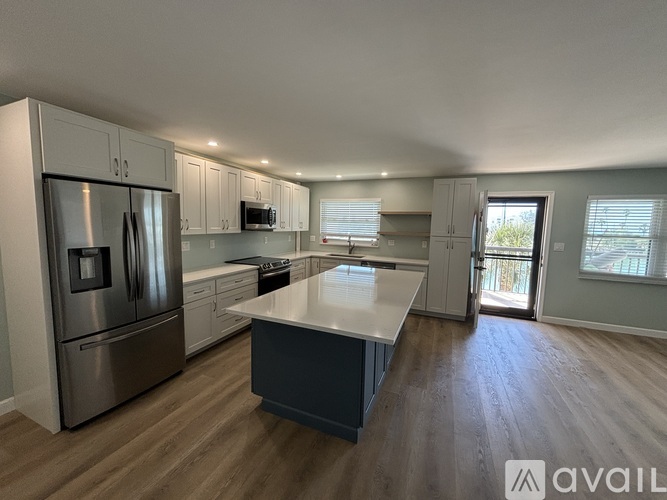 A kitchen with stainless steel appliances and a large island.