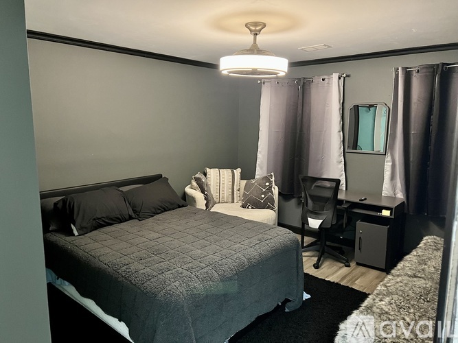 A bedroom with a bed, desk, and chair.