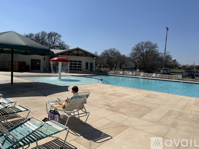 A person is sitting on a chair by a pool.