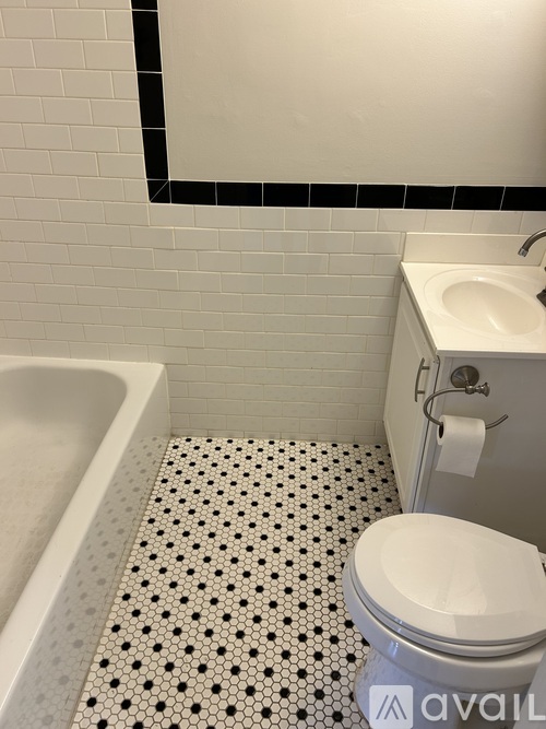 A white toilet with a roll of toilet paper on it.