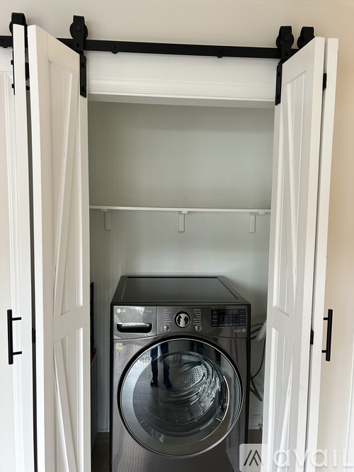A washing machine is in a small laundry room.