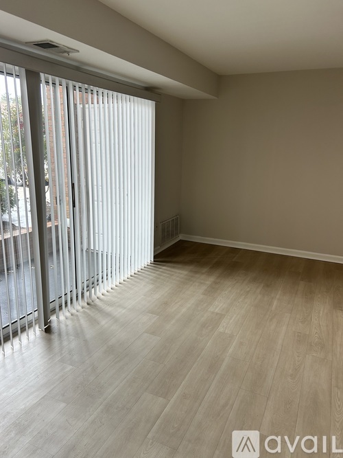 A room with wooden flooring and sliding glass doors.