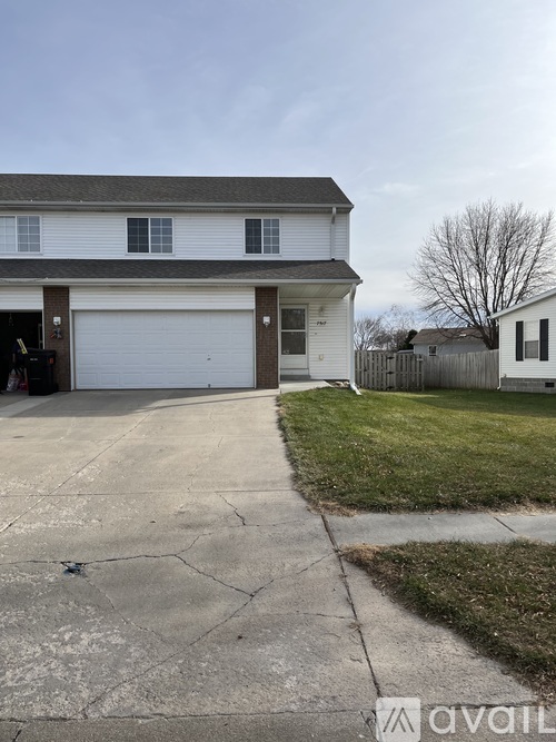A two-story house with a garage and a driveway.