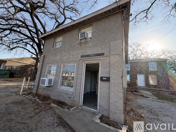 A small, single-story building with a brick facade and a doorway is for sale.