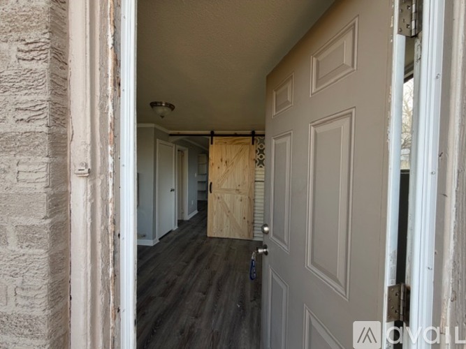 A hallway with a door on the right and a wall on the left.