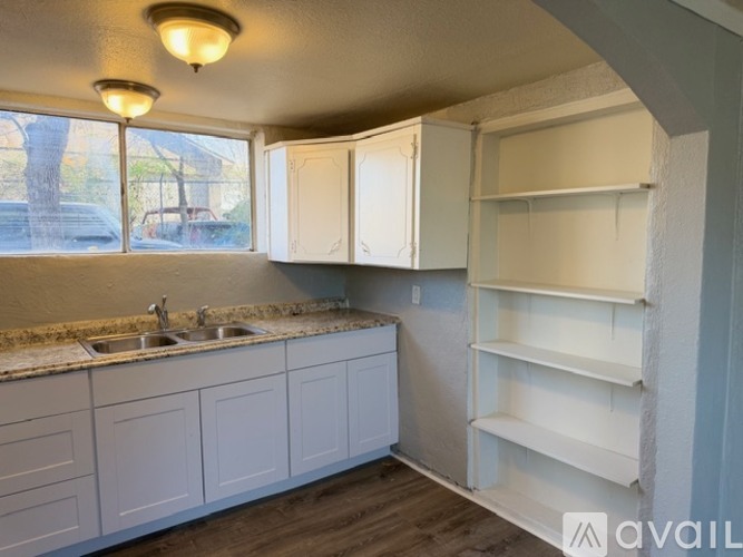 A kitchen with white cabinets and a sink.