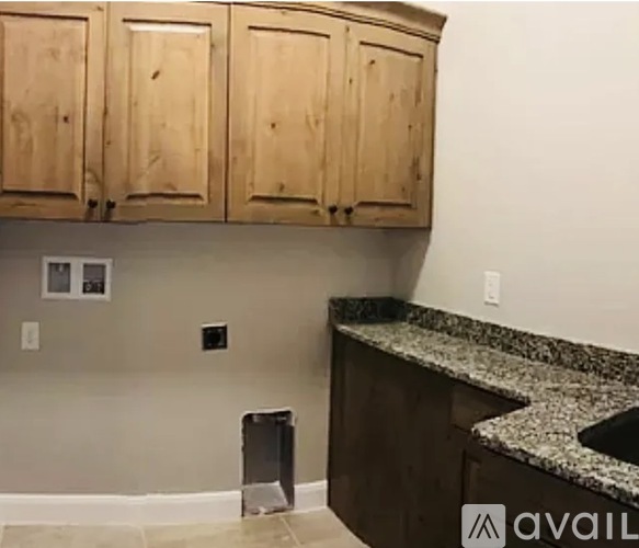 A kitchen with wooden cabinets and granite countertops.