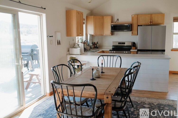 A kitchen with a table and chairs in front of it.