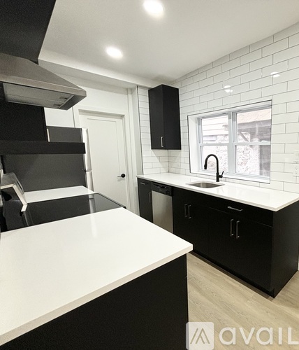 A kitchen with black cabinets and a white counter.