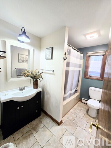 A bathroom with a white sink and a toilet.