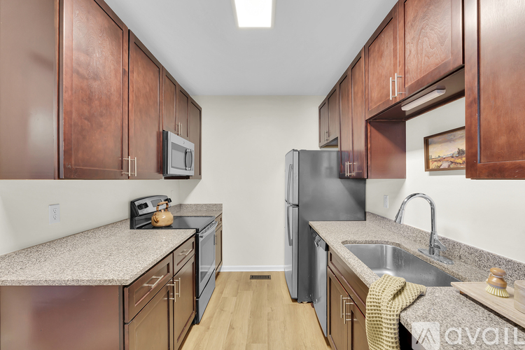 A kitchen with brown cabinets and a stainless steel refrigerator.
