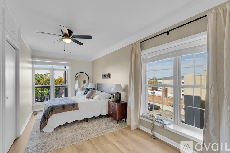 A bedroom with a large bed and a balcony overlooking a cityscape.