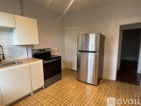 A kitchen with a sink, stove, and refrigerator.
