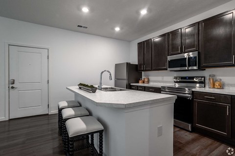 A kitchen with brown cabinets and a white island.