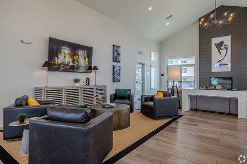 A modern living room with a fireplace and a large painting above it.
