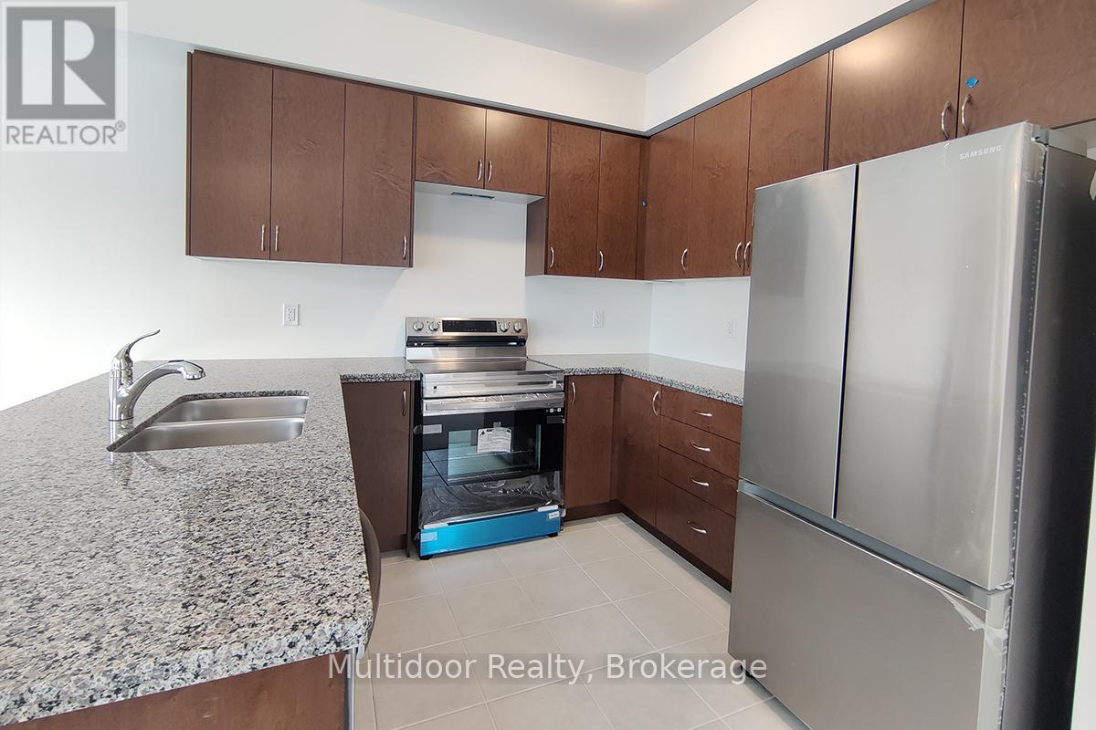 A kitchen with a granite countertop and stainless steel appliances.