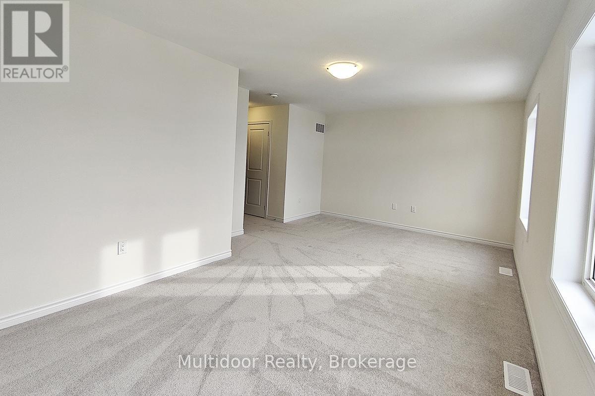A spacious, empty room with a carpeted floor and white walls.