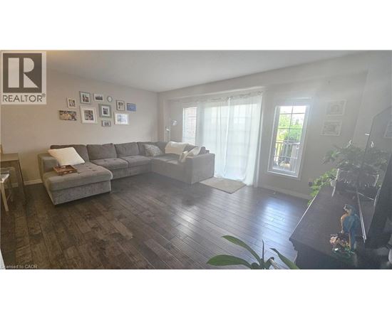 A living room with a grey couch and a wooden floor.