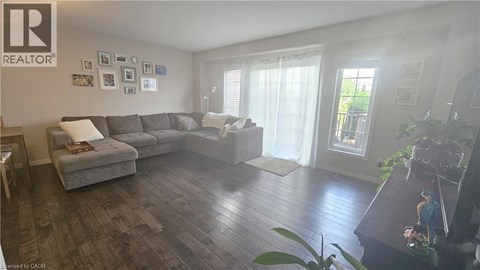 A living room with a grey couch and a wooden floor.