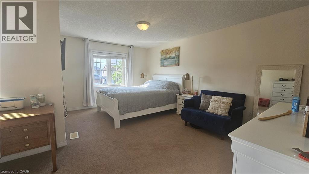 A bedroom with a bed, nightstand, and couch.