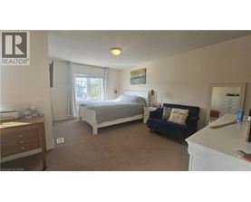 A bedroom with a bed, nightstand, and couch.