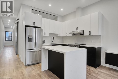 A modern kitchen with white cabinets and a central island.