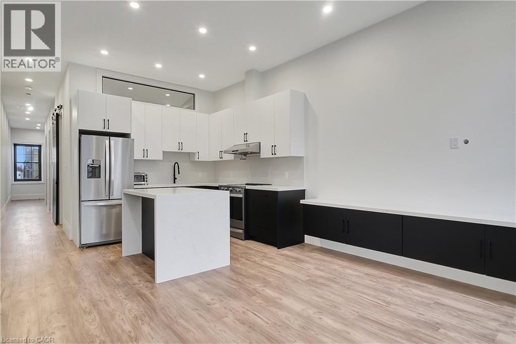 A modern kitchen with a white island and black cabinets.