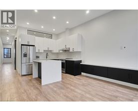 A modern kitchen with a white island and black cabinets.