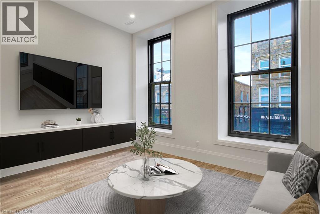 A living room with a flat screen TV mounted on the wall.