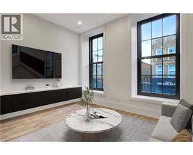 A living room with a flat screen TV mounted on the wall.