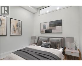 A bedroom with a large bed and two framed pictures on the wall.