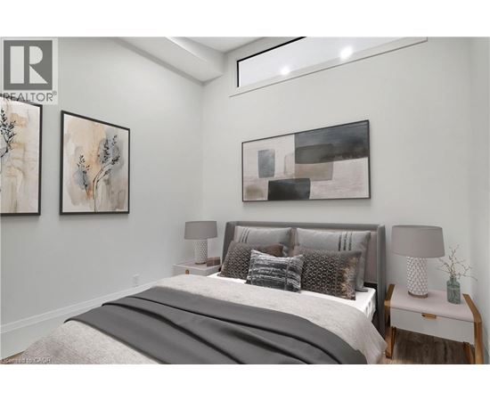 A bedroom with a large bed and two framed pictures on the wall.